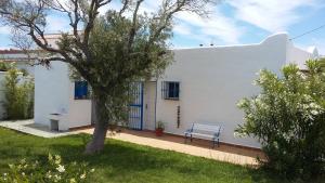 una casa blanca con un banco en un patio en Casa Montecote Playa, en Los Caños de Meca