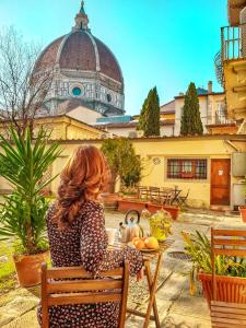 una mujer sentada en una silla frente a una mesa en La Gabbia del Grillo, en Florencia