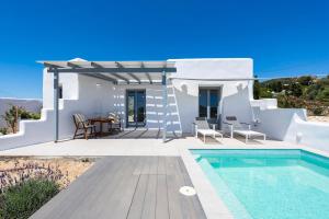 Una villa blanca con piscina y mesa. en Agkairia´s House, en Angairiá