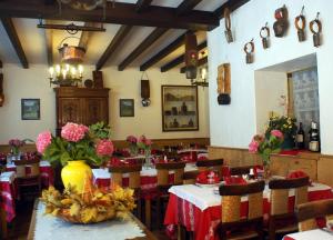 un restaurante con mesas y sillas con flores. en Hotel des Alpes en Brides-les-Bains