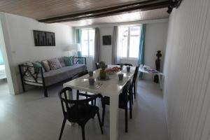 a living room with a table and chairs and a couch at Entre douceur et délicatesse in Colmar