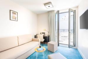 a living room with a couch and a table at Best Western Hôtel Journel Antibes Juan-les-Pins in Antibes