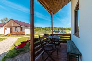 a patio with a table and chairs on a deck at Domek Werbena in Ustka