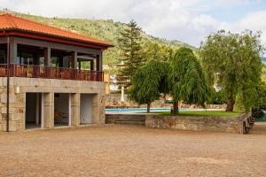 uma casa com varanda e uma árvore em Hotel Rural Quinta de Sao Sebastiao em Barroselas