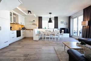 eine Küche und ein Wohnzimmer mit einem Tisch und Stühlen in der Unterkunft Villa Petersen "Himmel & Meer" in Wangerooge