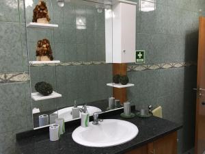 a bathroom with a sink and a mirror at Casa do Carroça in Terreiros +18 photos