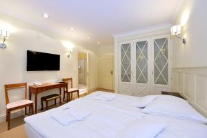 a bedroom with a white bed and a desk and a table at Villa Vanilla in Kędzierzyn-Koźle