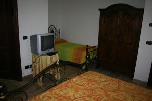 1 dormitorio con 1 cama y TV en una mesa en Agriturismo Colle del Sole, en San Martino in Colle