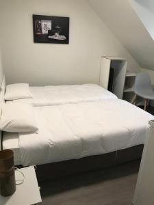 - une chambre avec un grand lit et des draps blancs dans l'établissement La Bonne Franquette, à Noizay