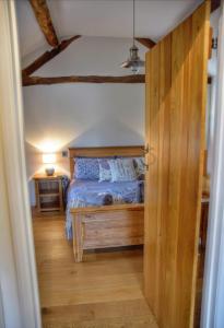 a bedroom with a bed and a wooden door at Smithy Cottage in Berriew