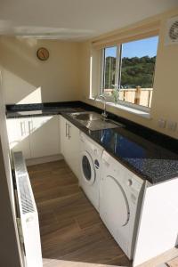 a kitchen with a sink and a washing machine at Granby in Nailsworth