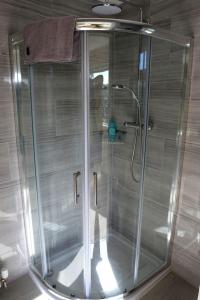 a shower with a glass door in a bathroom at Granby in Nailsworth