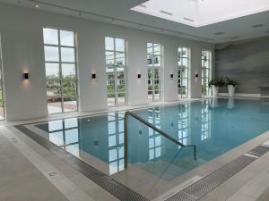 a large swimming pool with blue water in a building at Van der Valk Hotel Apeldoorn in Apeldoorn