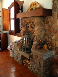 a stone fireplace with a stove in a kitchen at Hosteria Las Piedras in Puerto Madryn