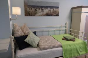 a bedroom with a bed with green sheets and pillows at Ferienwohnung BLAU in Hohenfelde