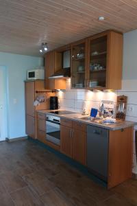 a kitchen with wooden cabinets and a counter top at Ferienwohnung BLAU in Hohenfelde