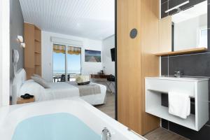 a hotel room with two beds and a bathroom at Hotel Les Dunes in La Tranche-sur-Mer