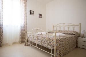 a bedroom with a bed with a floral bedspread at Appartamenti Duchessa in Castellammare del Golfo