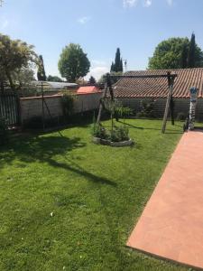 a backyard with a garden with a fence and grass at CASAMARTY in San Cesareo