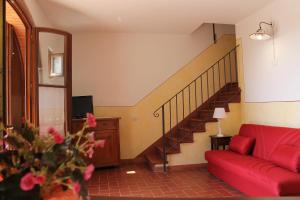 a living room with a red couch and a staircase at Agriturismo Poggio de Papi in Cantagrillo
