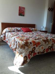 a bedroom with a bed with a floral comforter at CASAMARTY in San Cesareo