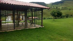 a gazebo with tables and chairs in a field at Quinta do Papagaio in Pouso Alto