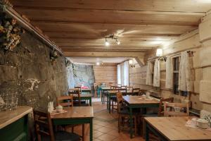 Willa Szwajcaria في فيسلا: مطعم بطاولات وكراسي خشبية في الغرفة