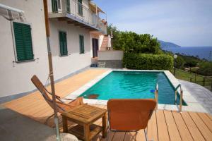 een zwembad met een tafel en stoelen naast een huis bij Ca Mè in Monterosso al Mare