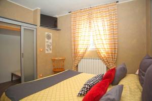 een slaapkamer met een bed met rode kussens en een raam bij Ca Mè in Monterosso al Mare