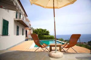 蒙特罗索阿尔马雷Ca Mè的带桌椅和遮阳伞的露台