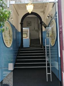 a hallway with stairs and a chandelier at Residencial do Sul in Lisbon