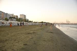 a group of people walking on the beach at Hai Hotel in Larnaca