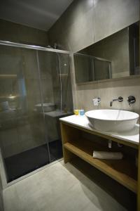 a bathroom with a sink and a glass shower at Hai Hotel in Larnaca