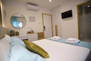 a bedroom with a white bed and a mirror at Hai Hotel in Larnaca