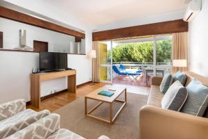 a living room with a couch and a table at Apartamentos Turisticos Pinhal Da Marina in Vilamoura