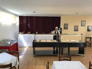 a man standing behind a table in a room at HTP Velika Plaža Ulcinj in Ulcinj