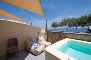 eine Badewanne auf dem Balkon mit Meerblick in der Unterkunft Cyclops Beach Apartments in Perivolos