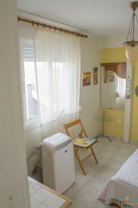 a living room with a small refrigerator and a chair at Beautiful apartment (very high ceiling) next to the beach with 2 separate bedrooms in Polykhrono