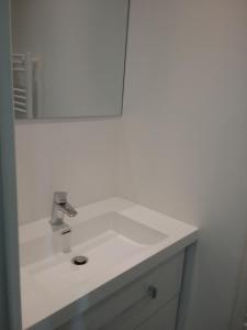 ein weißes Waschbecken im Bad mit Spiegel in der Unterkunft Studio in Cancale