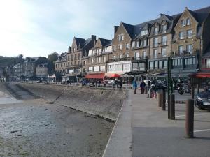 a town with buildings and a beach with people walking at Studio in Cancale