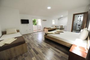 a large room with two beds and a television at Stella Apartments in Gevgelija