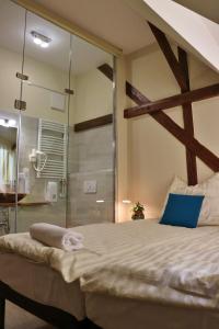 1 dormitorio con 1 cama grande y ducha de cristal en Kenguru Panzió, en Hódmezővásárhely