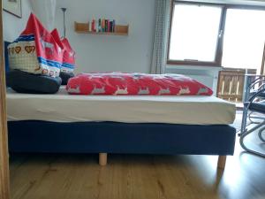 Bett mit roten Kissen auf einem Zimmer in der Unterkunft Haus am Wiesenrain in Leutasch