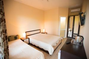 a bedroom with two beds and a tv on the wall at Октябрьская 318 SINGER СИНГЕР in Tsandrypsh