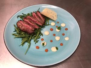 a plate of food with meat and vegetables on a table at Luna Blu in La Spezia