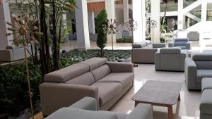 a lobby with a couch and chairs in a building at Hipotels Barrosa Park in Chiclana de la Frontera