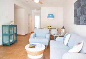 a living room with blue chairs and a table at Can Serol Apartaments in Capdepera +11 photos