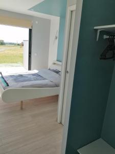 ein Schlafzimmer mit einem Bett und einer Wand mit einem Fenster in der Unterkunft Le Temps d'un Rêve in Eauze