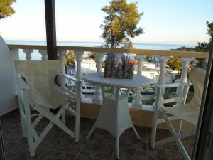 una mesa y sillas en un balcón con vistas en Machi Rooms, en Patitiri