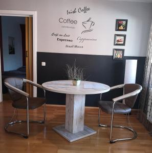 einen Tisch und Stühle in einem Zimmer mit einer Wand in der Unterkunft Apartment Am Radweg in Wetzlar